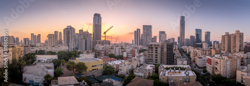 Aerial sunset panorama view of Tel Aviv financial district, Givatayim, , Givat Amal, Tel Binyamin, Givat Rambam, Montefiore with skyscrapers and cranes working on new construction in Israel