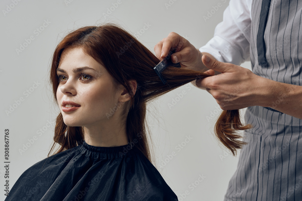 Fototapeta premium hairdresser cutting hair with scissors