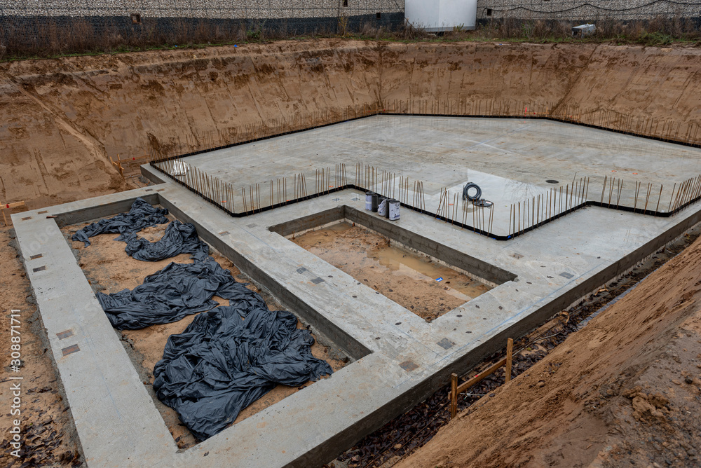 Die Baugrube mit Betonfundament eines Einfamilienhauses Die Baugrube mit Betonfundament eines Einfamilienhauses