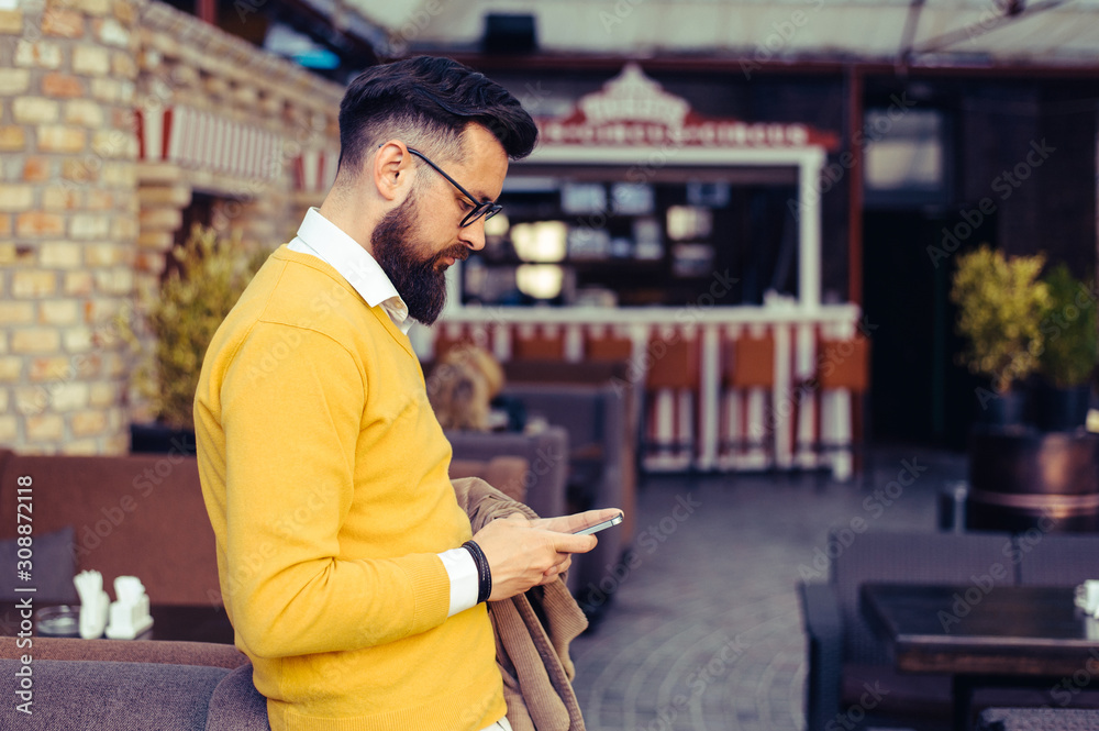 Handsome young man with a phone in his hand Handsome young man with a phone in his hand