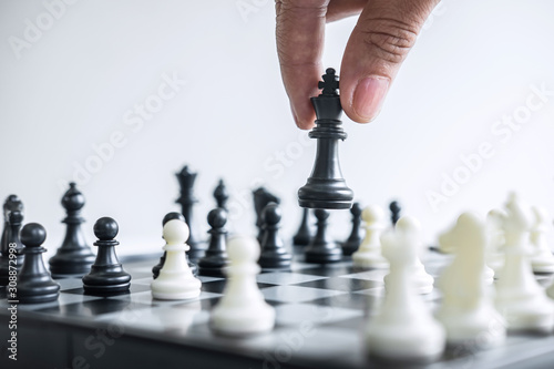 Business woman playing chess and thinking strategy about crash overthrow the opposite team and development analysis for win and successful photo