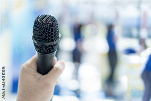 Close up of hand holding microphone for speaker at event