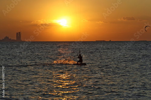  A lone wind surfer rides the sea against the backdrop of a golden sunset dubai