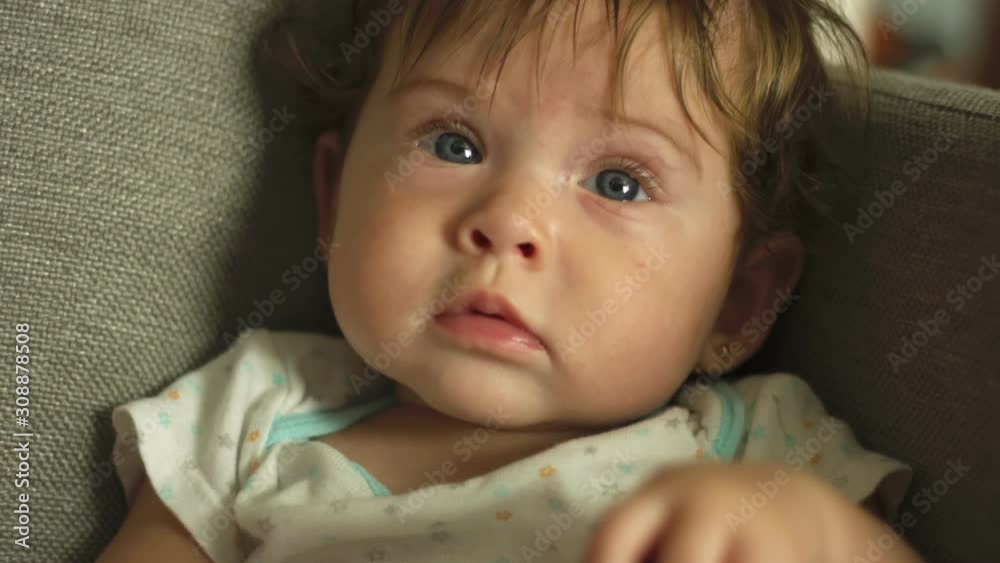 Close-up of baby with blue eyes looking towards camera and smiling Close-up of baby with blue eyes looking towards camera and smiling