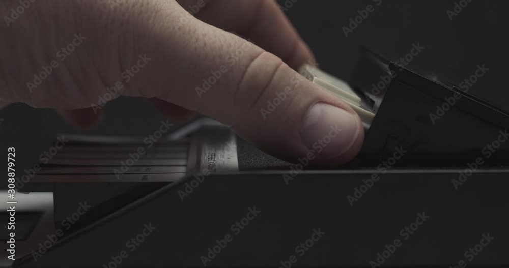 Ejecting tape and pulling it out on retro audio cassette tape player