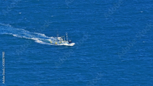 青空映す海原を疾走する漁船 © Scott Mirror