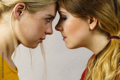 Two girls looking serious at each other.