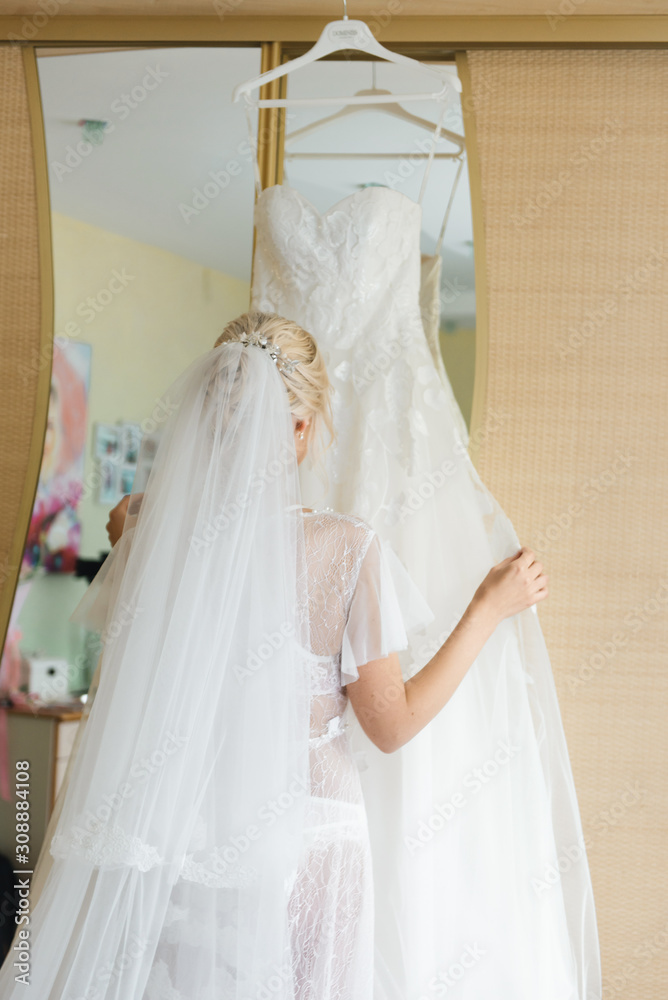 The details of the wedding day. The bride adjusts her wedding dress The details of the wedding day. The bride adjusts her wedding dress