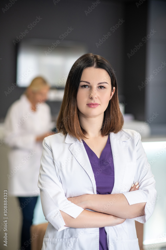 Beautiful dark-haired doctor in white robe looking confident Beautiful dark-haired doctor in white robe looking confident