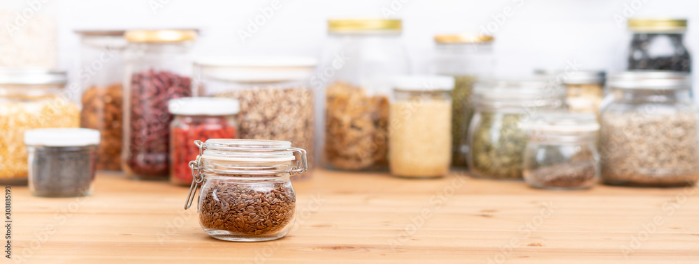 Banner, Brown flax seeds and various healthy dried Legumes, beans - sunflower, pumpkin seeds, red bean, lentil, walnuts, almond - in beautiful glass airtight container jars on wooden kitchen table Banner, Brown flax seeds and various healthy dried Legumes, beans - sunflower, pumpkin seeds, red bean, lentil, walnuts, almond - in beautiful glass airtight container jars on wooden kitchen table