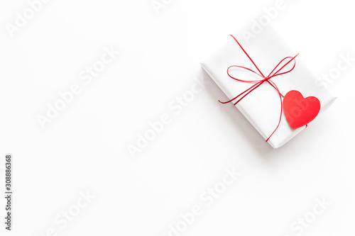 Valentine's Day gift. Present box near paper hearts on white background top-down copy space