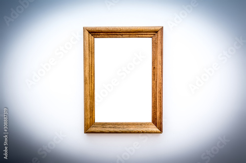 A simple wooden vertical photo frame close-up with an isolated white background inside with soft shadows.