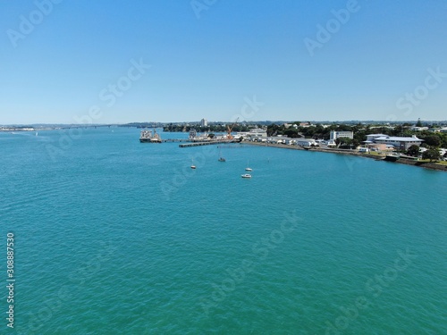Devonport, Auckland / New Zealand - December 11, 2019: The Victorian Style Seaside Village of Devonport, with the skyline of Auckland’s landmarks and CBD in the background © Julius