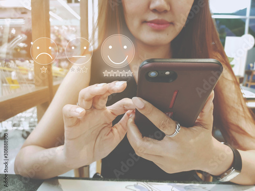 Customer Experience Concept, happy Business women holding the smartphone with a checked box on Excellent Face and Rating for a satisfaction survey. photo