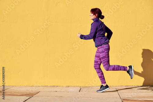 woman running with winter clothes for fitness - sports concept