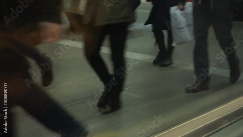 People walking on a busy train station, seen from departing train Slow motion