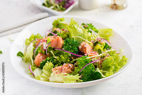 Salad of baked fish salmon, broccoli, lettuce, red onion and dressing. Fish menu. Seafood - salmon.
