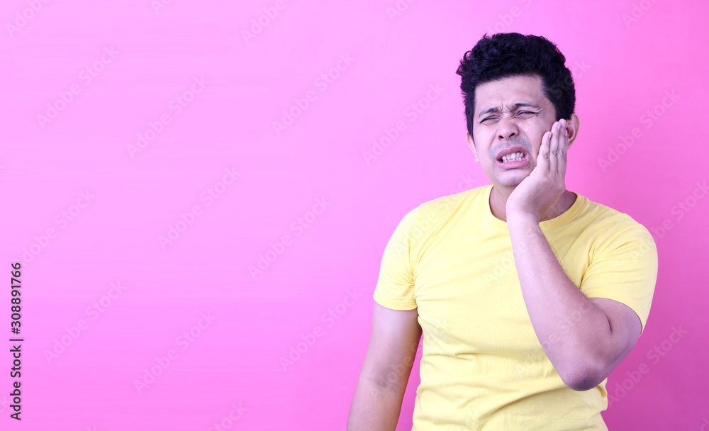 Young Asia man with a toothache on pink background in studio With copy space. Young Asia man with a toothache on pink background in studio With copy space.