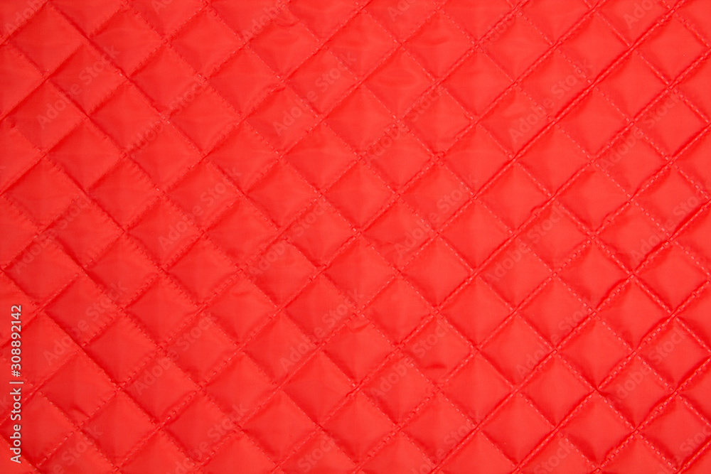 Quilted fabric. The texture of the blanket.	Red textile