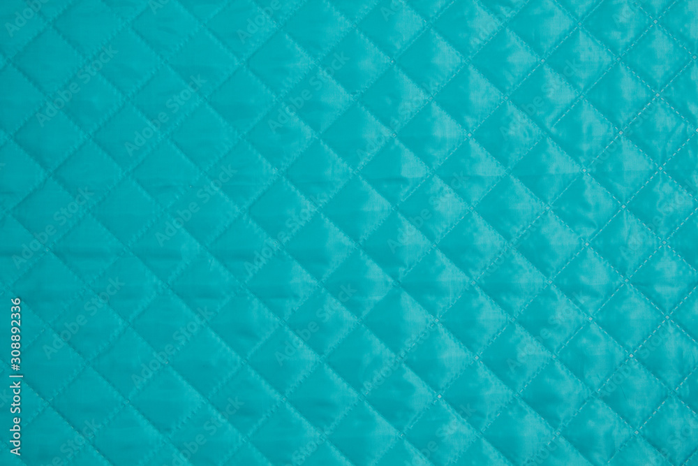 Quilted fabric. The texture of the blanket. Blue textile Quilted fabric. The texture of the blanket. Blue textile