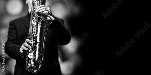 Photography The saxophone player at the jazzclub - open place for text on black background