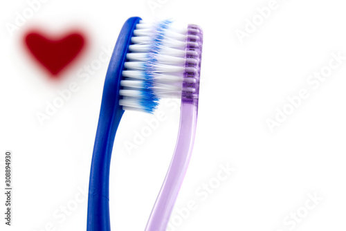 couple of pink and blue toothbrushes isolated over white background. love concept for valentine's day