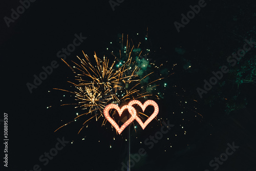 Golden big shiny fireworks with bokeh lights in the night sky. Glowing firework show. New Year or wedding photo