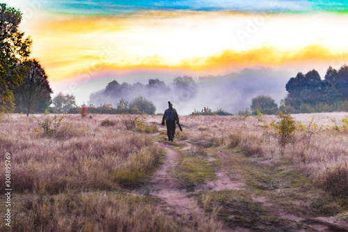 Man goes through field towards burning site. Ukraine