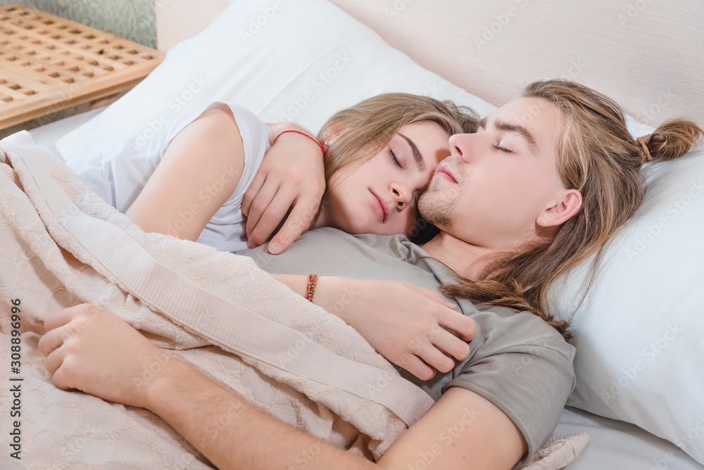 beautiful married couple lies hugging in bed, life together, relationship in a pair beautiful married couple lies hugging in bed, life together, relationship in a pair