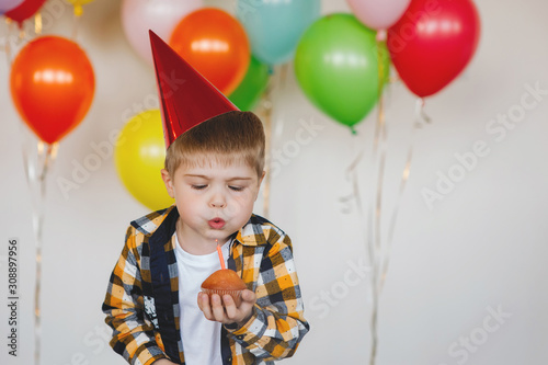 Boy blows out a birthday candle.
