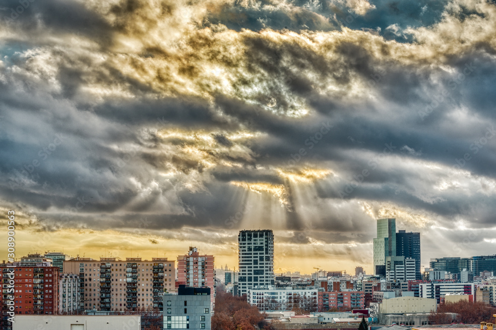 Fototapeta premium paisaje urbano con el cielo encapotado de nubes y rayos de sol
