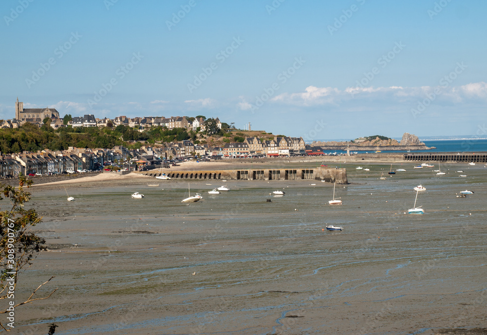 Boats on dry land at the beach at low tide in Cancale famous oysters production town, Brittany, France,