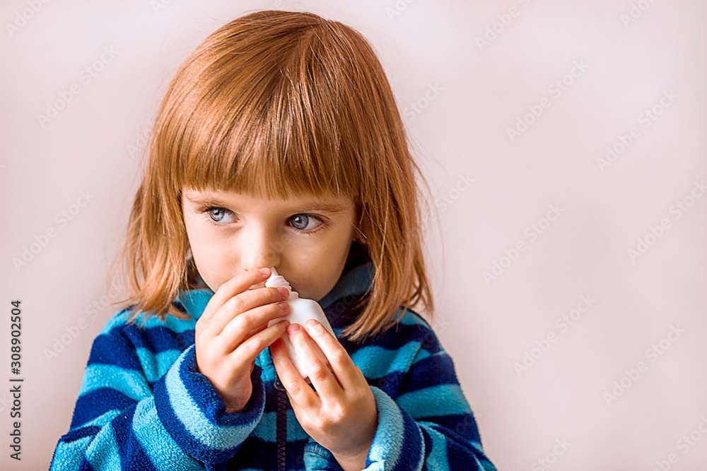 beautiful little girl uses a nasal spray for allergies or illness, plain background, the concept of colds and viral seasonal diseases beautiful little girl uses a nasal spray for allergies or illness, plain background, the concept of colds and viral seasonal diseases
