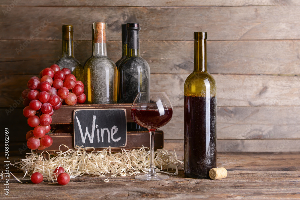 Naklejka premium Box with bottles of different wine on wooden table