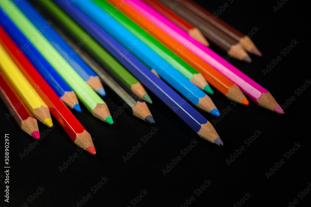 .GROUP OF COLORED PENCILS ALIGNED ON BLACK BLACKGROUND .GROUP OF COLORED PENCILS ALIGNED ON BLACK BLACKGROUND