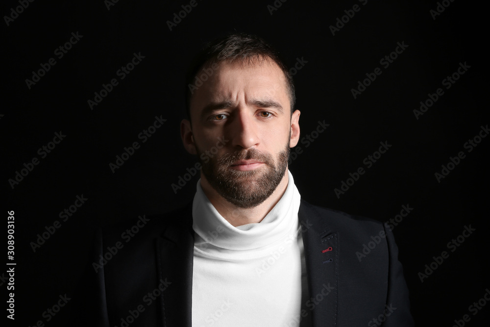 Portrait of stylish young man on dark background