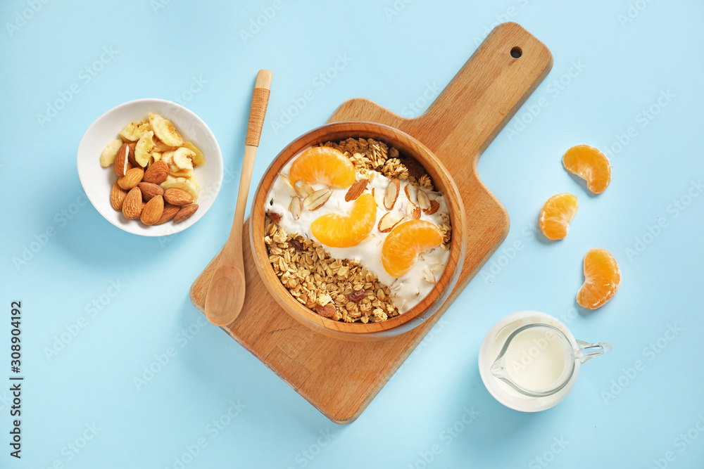 Fototapeta premium Tasty granola with yogurt in bowl on color background