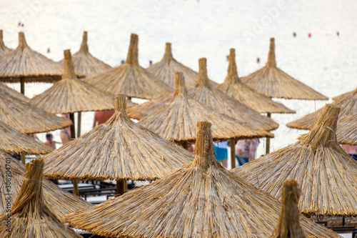 on the beach there are many rows of umbrellas which are covered with straw on the beach
