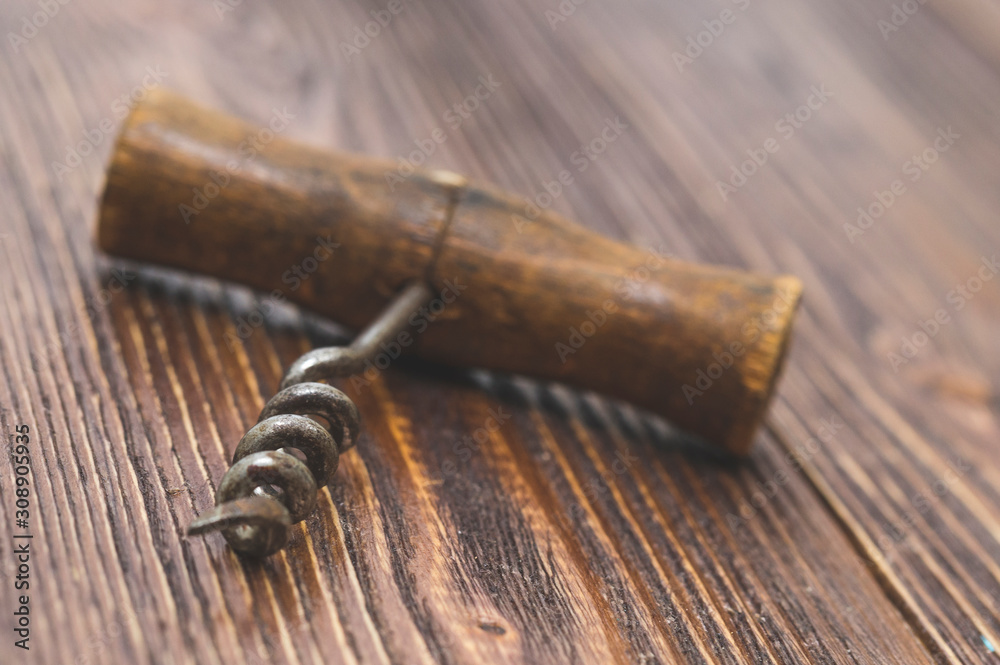 old corkscrew close-up on wooden background, macro photo, selective focus