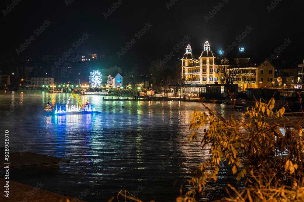 Velden am Woerthersee. Reflections on the water and Christmas atmosphere. Advent wreath and floating crib. Austria.