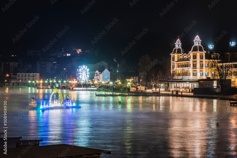 Velden am Woerthersee. Reflections on the water and Christmas atmosphere. Advent wreath and floating crib. Austria.