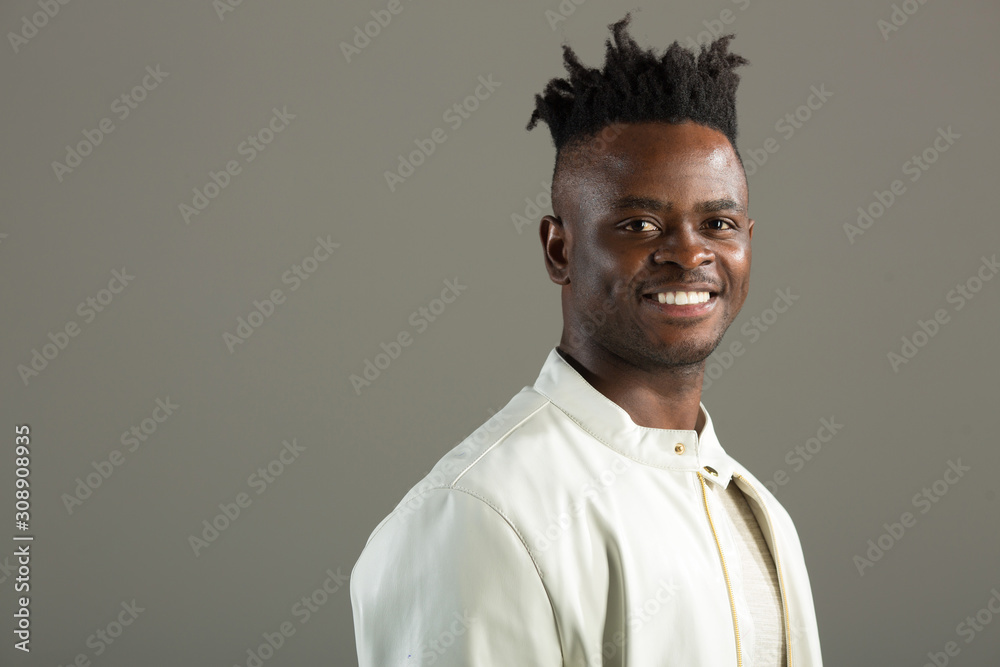 Obraz premium handsome african man in a white jacket on a gray background