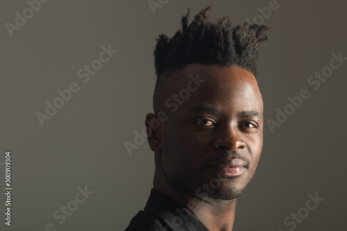 handsome african man in black suit on gray background