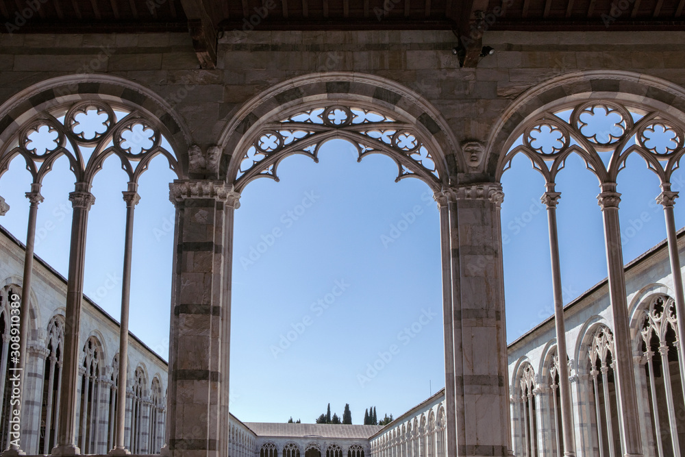Fototapeta premium View on internal patio of Camposanto Monumentale di Pisa. Monumental Cemetery, Interior courtyard. Ornate columns and. Interior view. Italy, Tuscany.