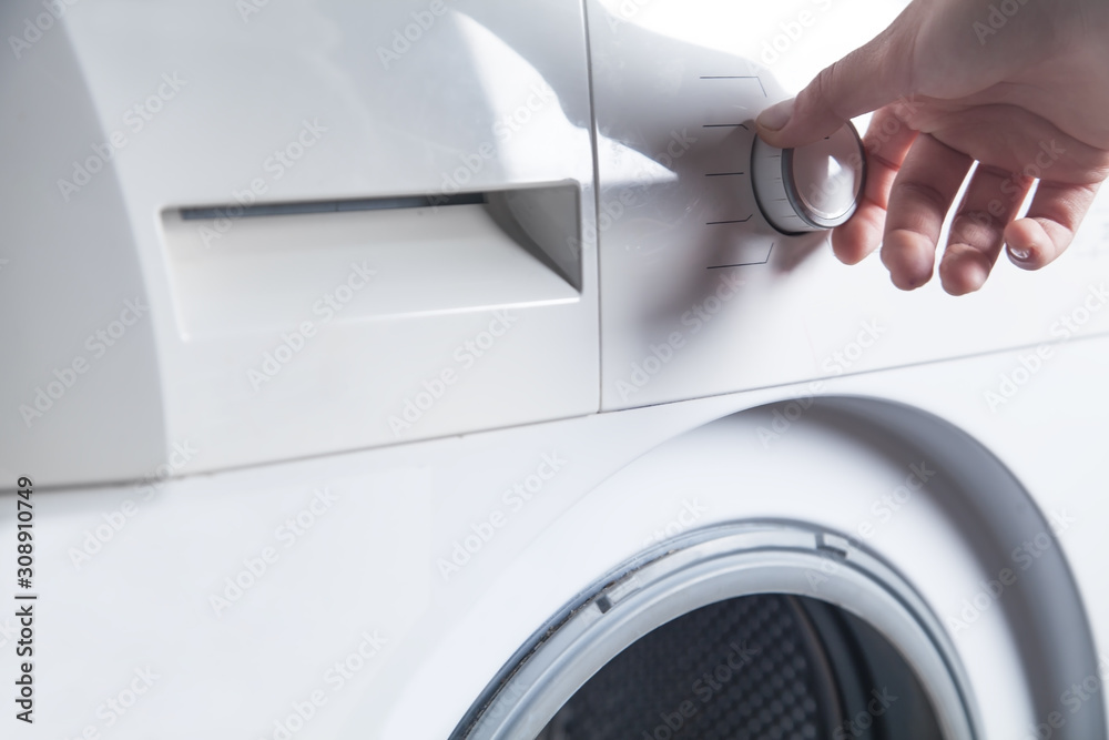 Girl hand is turning knob of washing machine. Girl hand is turning knob of washing machine.