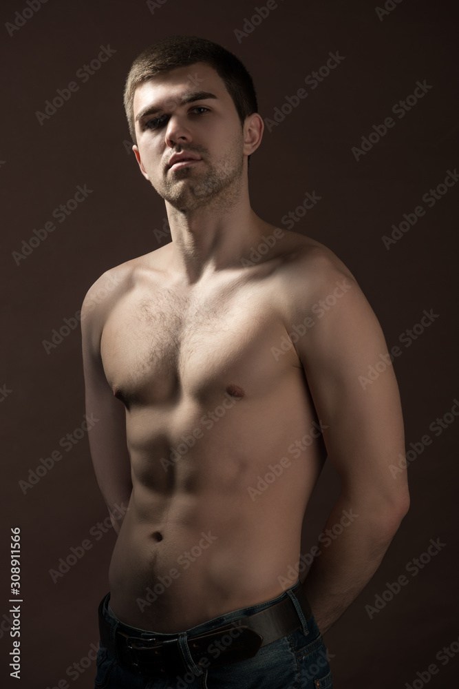 Fototapeta premium Young man model in brown underpants standing and showing his body