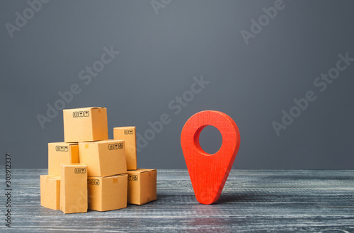 Red location pointer geolocation symbol and cardboard boxes. Distribution delivery of goods, freight transportation shipment. Logistics and warehousing. Global market and business, import and export. photo