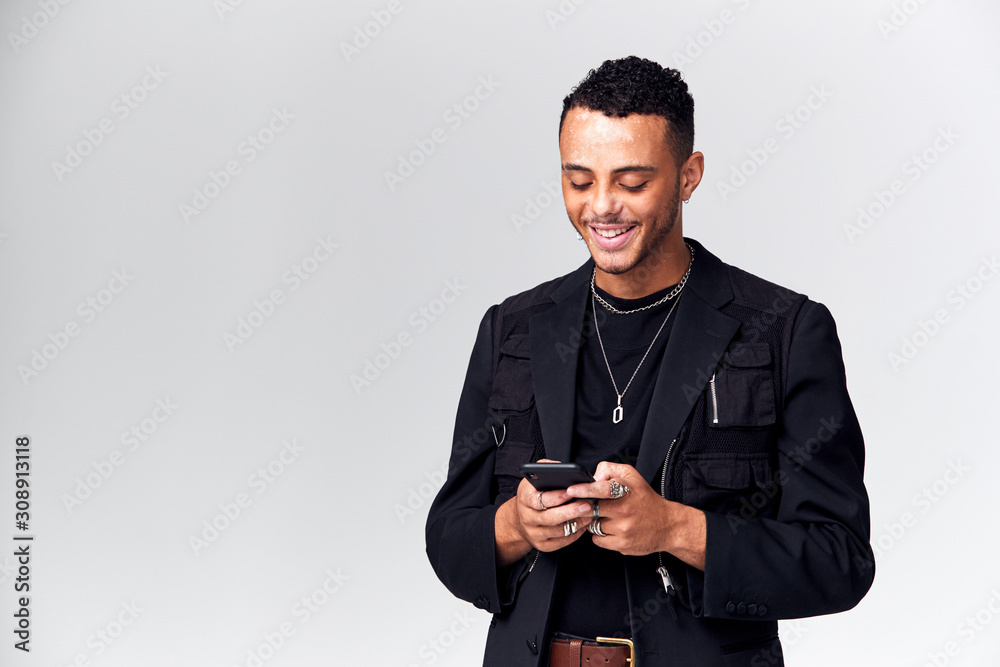 Studio Shot Of Causally Dressed Young Man Using Mobile Phone Studio Shot Of Causally Dressed Young Man Using Mobile Phone