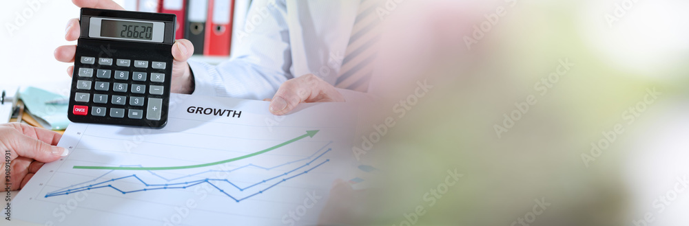 Businessman showing financial result on a calculator; panoramic banner Businessman showing financial result on a calculator; panoramic banner