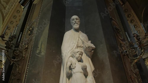 Statue of catholic saint in church with light halo over head Saint Joseph by Pal Patzay in temple St. Stephen's Basilica in Budapest Hungary gimbal smooth camera movement